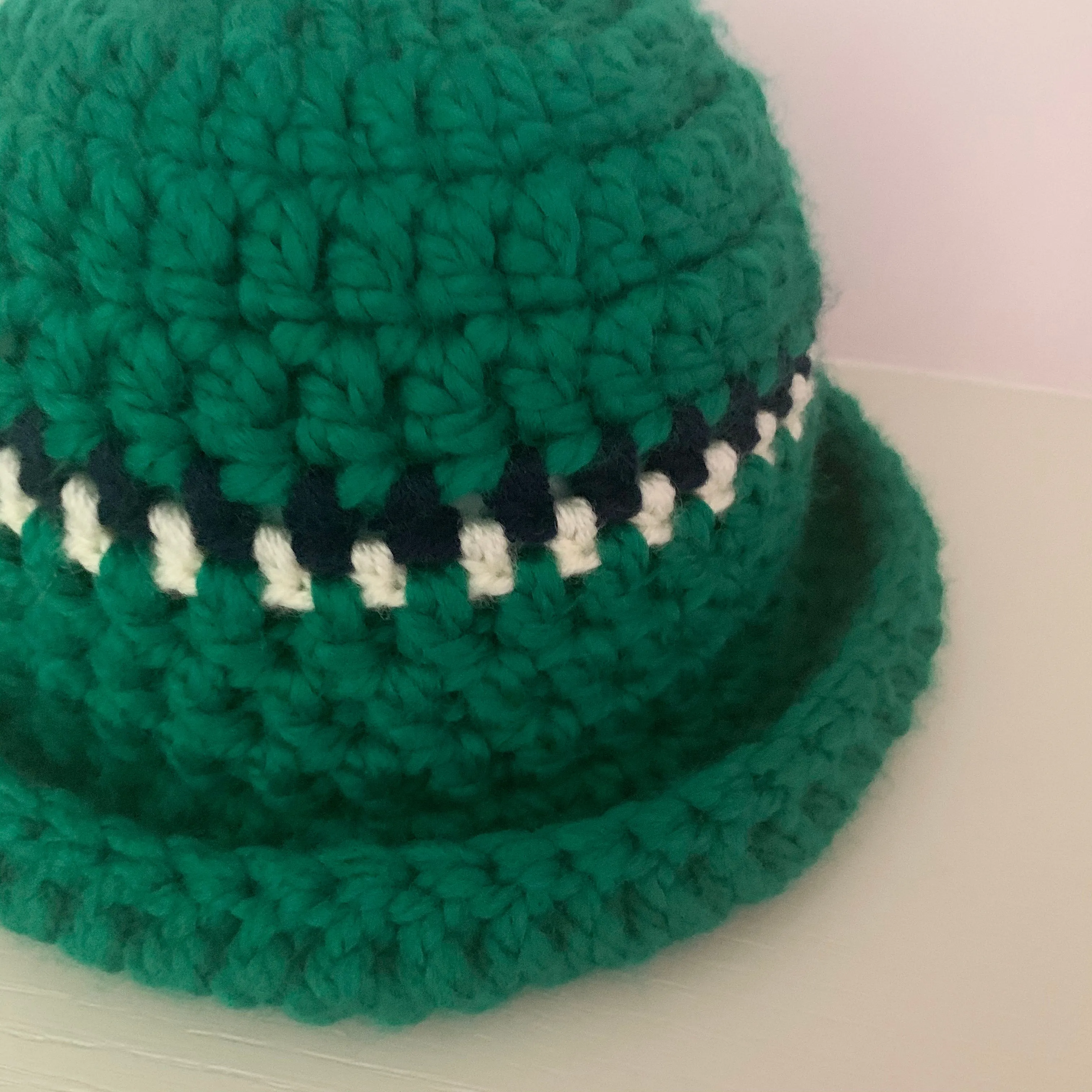 Handmade forest green chunky crochet bowler hat with cream and navy stripes