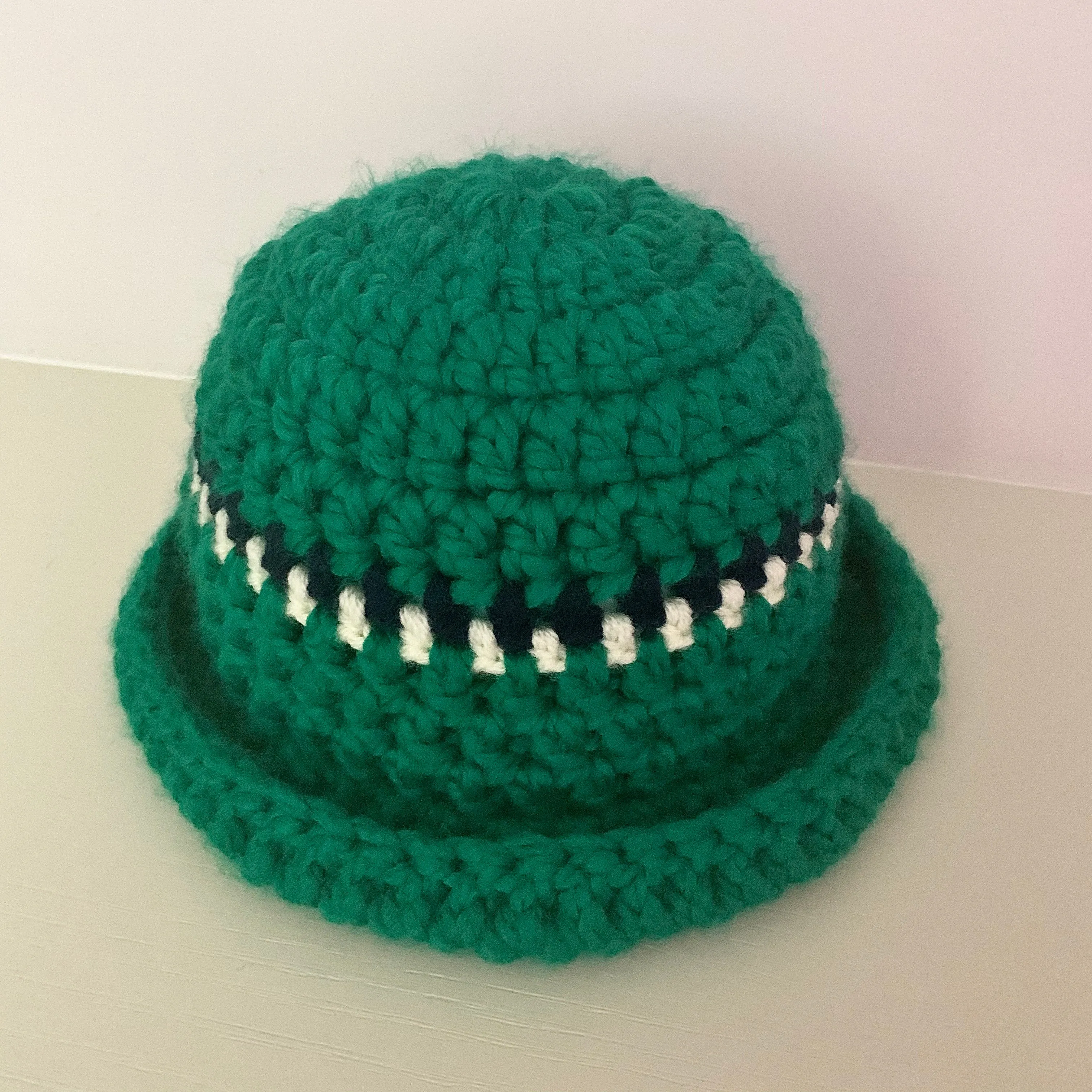 Handmade forest green chunky crochet bowler hat with cream and navy stripes